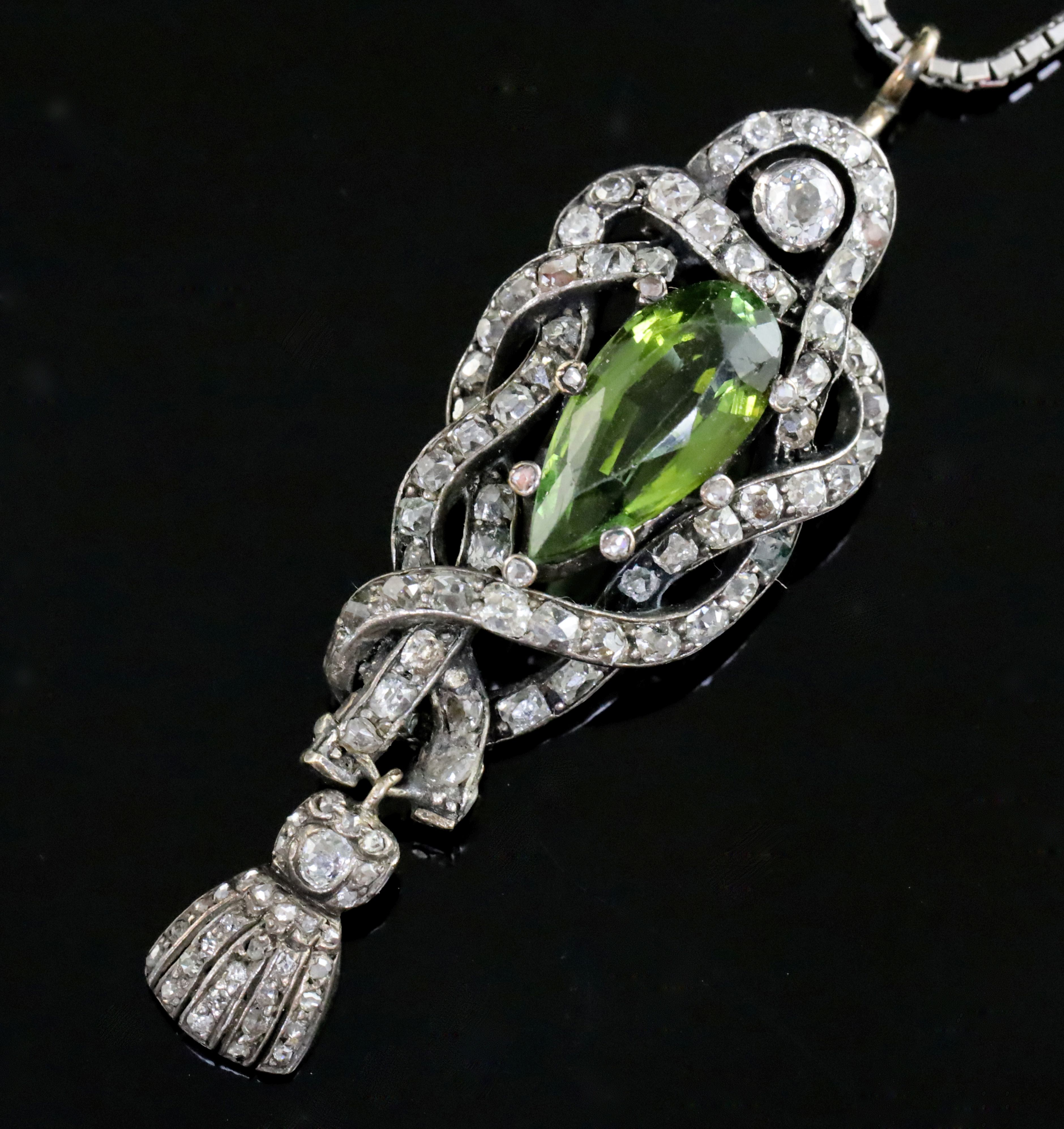 A Victorian gold and silver green tourmaline and diamond set drop pendant, of scrolling design, with