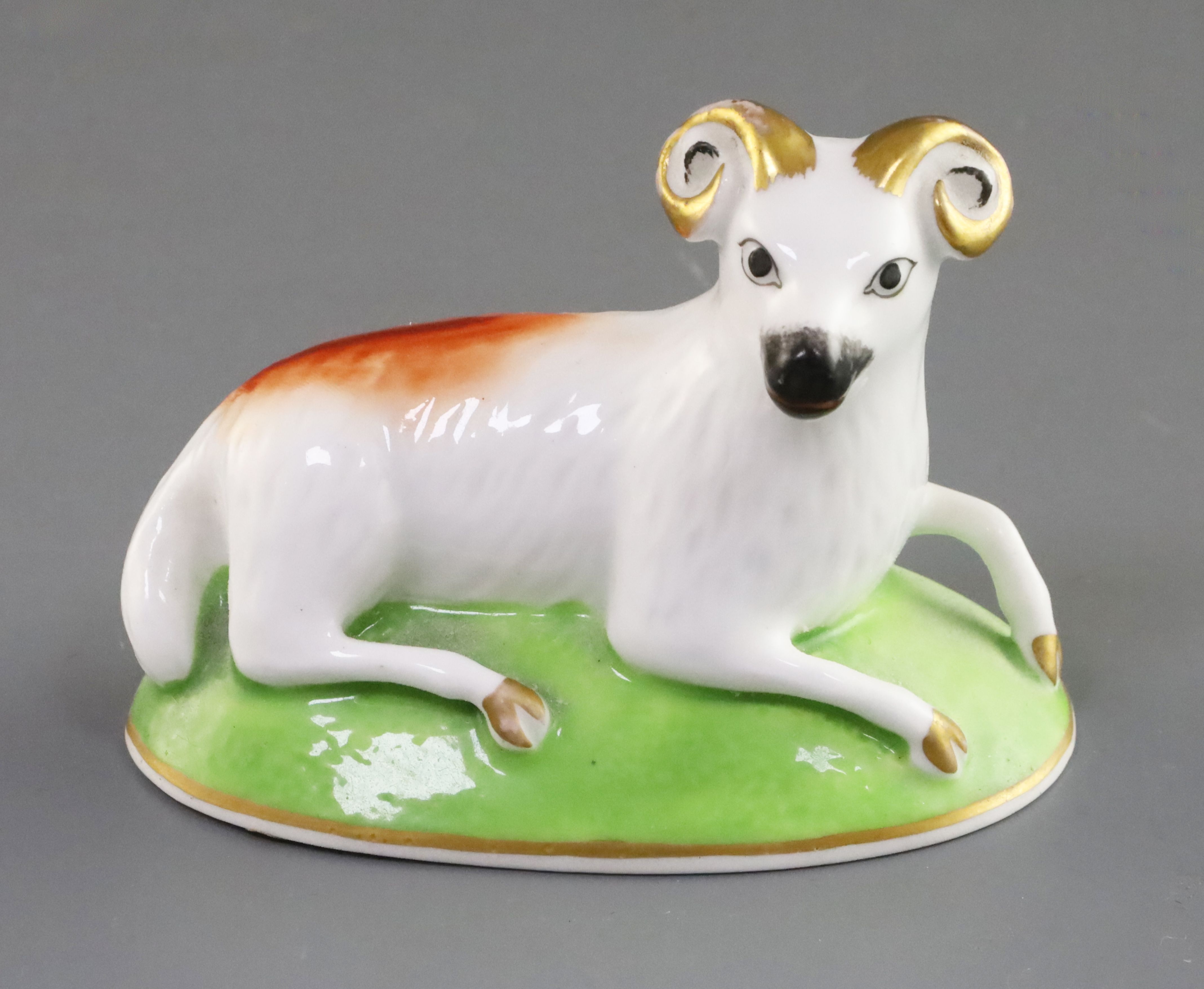 A Charles Bourne porcelain figure of a ram, c.1817-30, recumbent on green oval mound base,