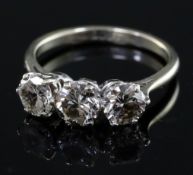 An 18ct white gold and three stone diamond ring, the central stone with a diameter of