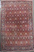 A Persian red ground carpet, with central field of octagons and foliate motifs, multi-bordered, 11ft