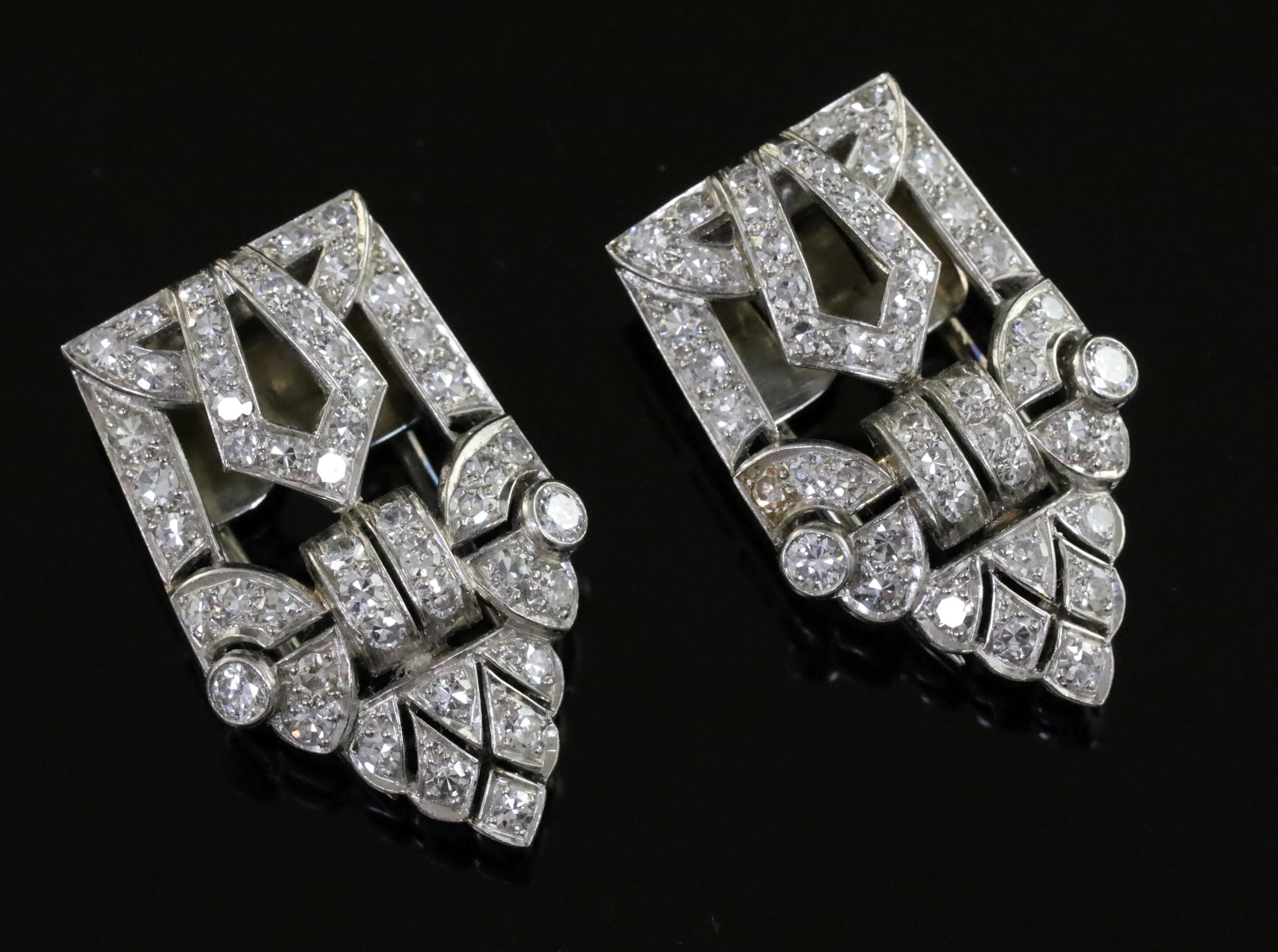 A pair of Art Deco diamond dress clips, of typical openwork geometric form, millegrain-set in