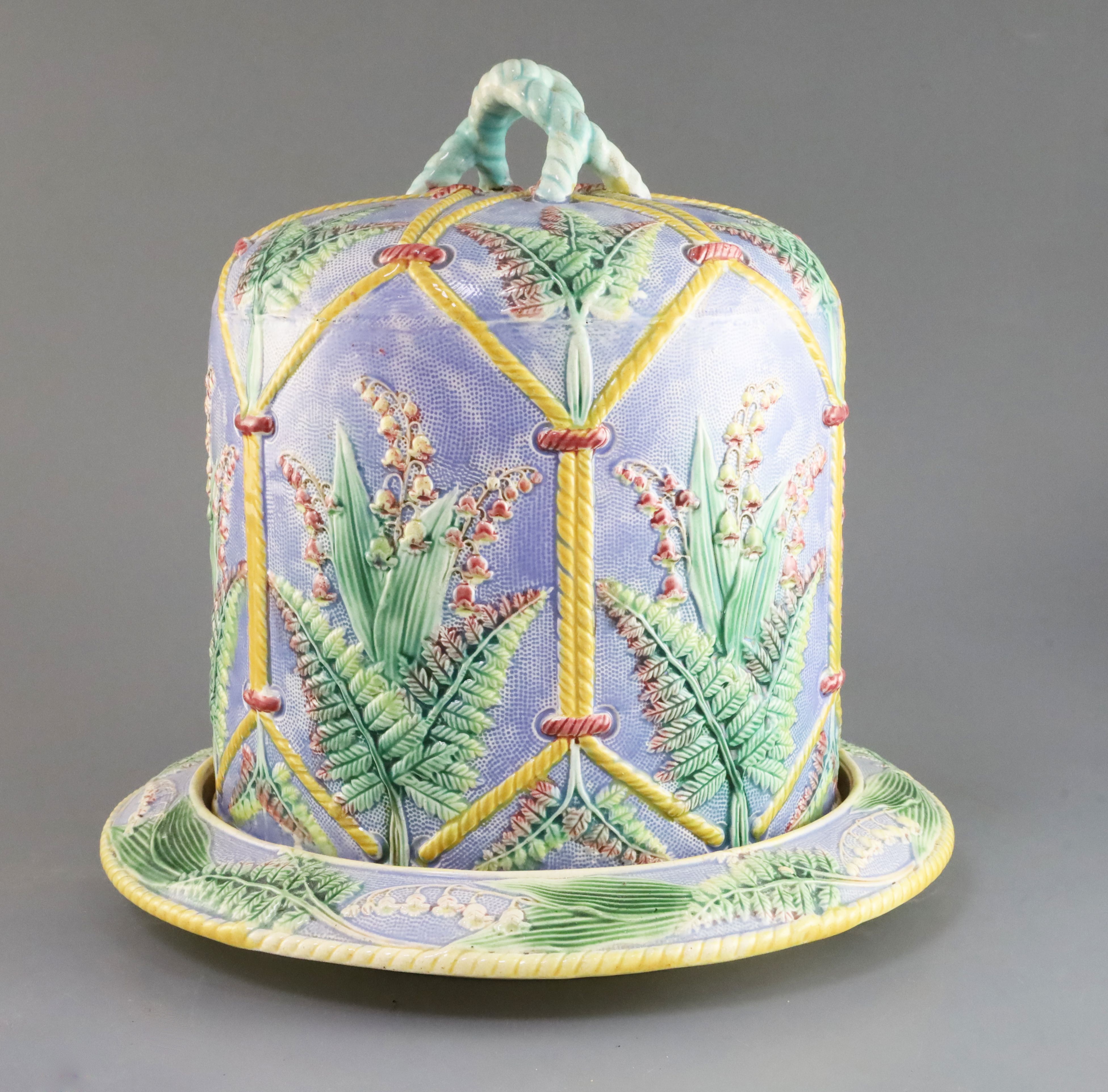 A Victorian majolica cheese dome and stand, decorated with ferns, H. 12.25in., faults