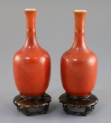 A pair of Chinese coral ground bottle vases, Hongxian mark, Republic period, H. 14cm, wood stands,