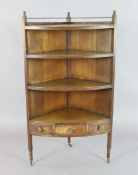 A Regency oak bowfront corner whatnot, with base drawer, on tapered legs with fitted brass