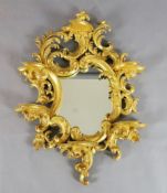 A 19th century Florentine giltwood wall mirror, of asymmetrical scroll design with six shelves, W.