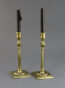 A pair of mid 18th century brass candlesticks, with fluted stems and square bases, 9in.