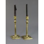 A pair of mid 18th century brass candlesticks, with fluted stems and square bases, 9in.