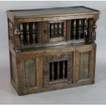 A 17th century oak glass or trencher case, with turned columns and carved foliate motifs, W.2ft 9in.