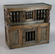 A 17th century oak glass or trencher case, with turned columns and carved foliate motifs, W.2ft 9in.