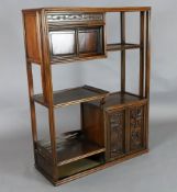A Chinese hongmu display cabinet, c.1910, with an arrangement of cupboards and a drawer carved in
