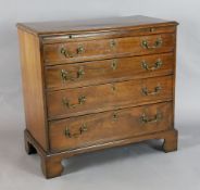 A George III mahogany chest, with brushing slide and four graduated long drawers, on bracket feet,