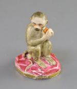 A Rockingham porcelain figure of a seated monkey, c.1830, holding a fruit in its hands, incised 'No.