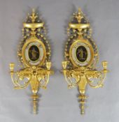 A pair of Hepplewhite style giltwood and gesso girandoles, the central oval plates inset with relief