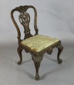 A George III Irish mahogany dining chair, with elaborate flower and scroll carved and pierced splat,