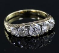 A late Victorian gold and graduated five stone diamond half hoop ring, with pierced carved setting