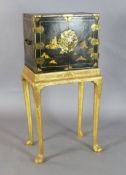 An early 18th century Japanese black lacquer cabinet, decorated with houses in a landscape, trees,