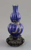 A small Chinese blue glazed double gourd vase, 18th/19th century, lobed and with a gilt ribbon