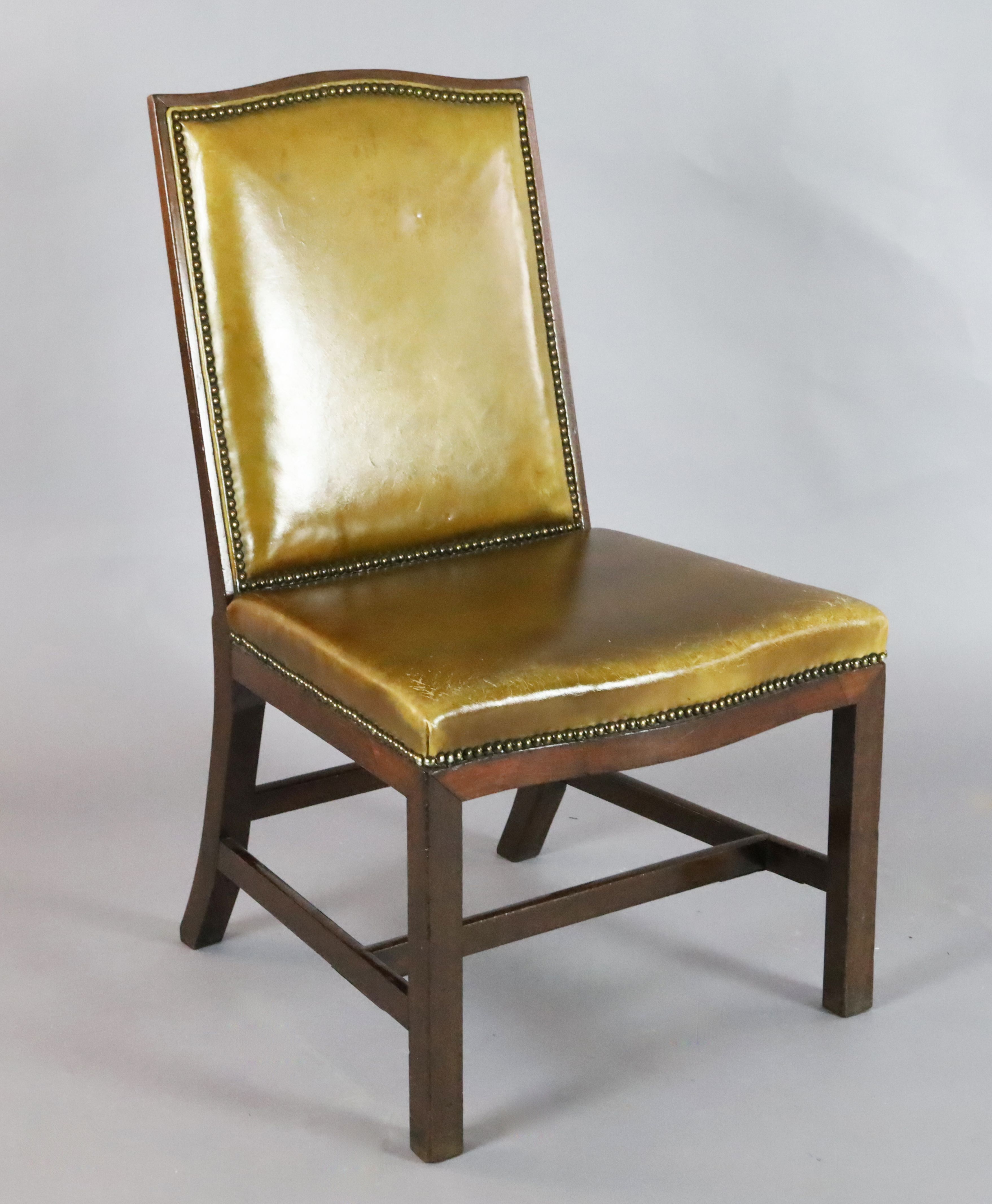 A George III style mahogany desk chair, with pale green leather upholstery, on chamfered squared