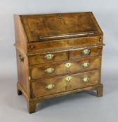 A mid 18th century featherbanded walnut bureau, the fall enclosing central cupboard., 'secret