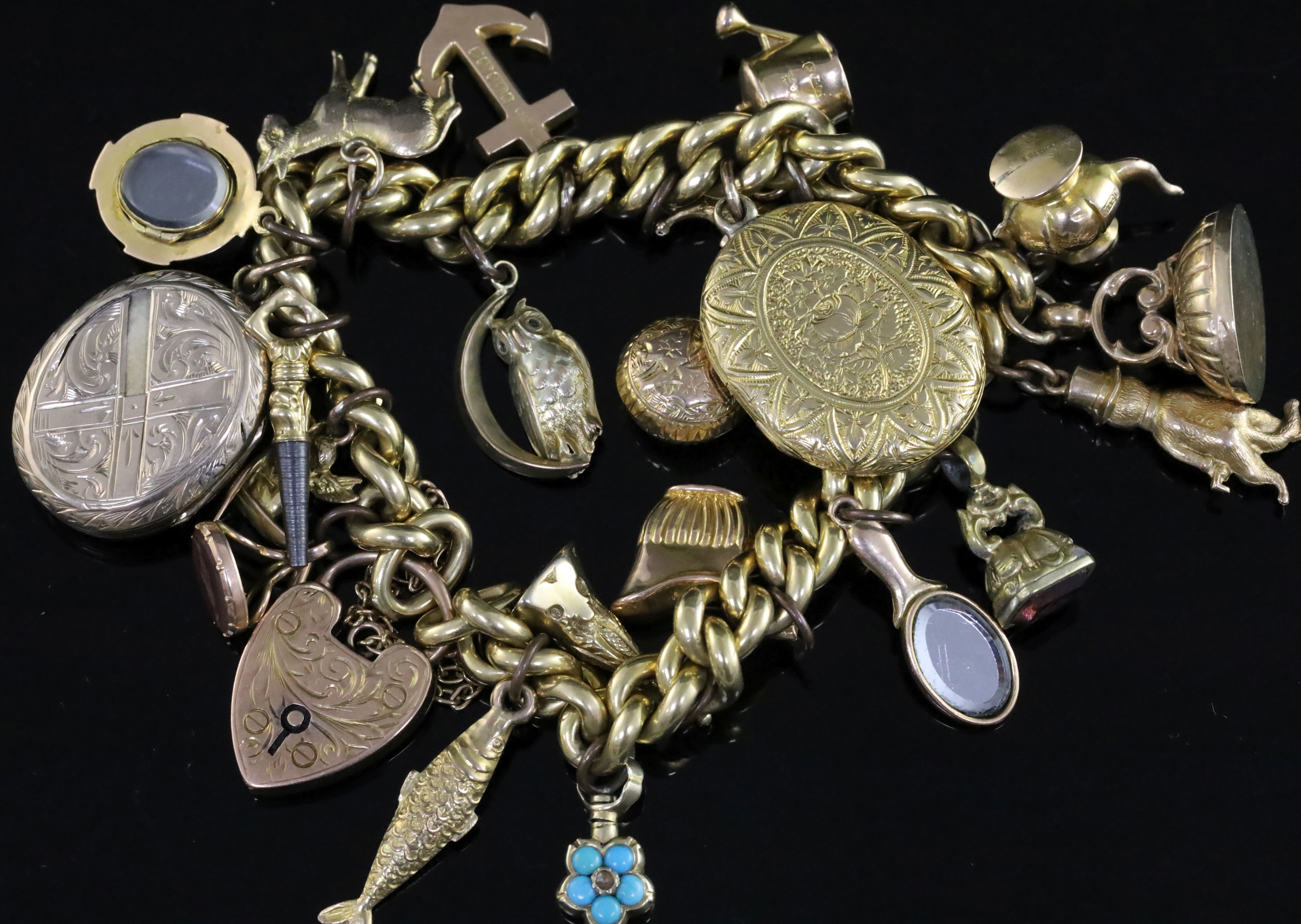A 9ct gold charm bracelet, hung with twenty one assorted charms, including coffee pot, seals etc,