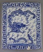 A Chinese blue and white 'dragon' plaque, 19th century, painted with a dragon chasing a flaming