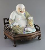 A Chinese famille rose seated figure of Budai, Republic period, holding a rosary in his left hand,