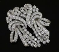 A mid 20th century white gold and diamond double clip scroll brooch, set with round and baguette cut