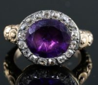 A George III gold, foil backed amethyst and diamond set oval ring, with carved shank, size L.