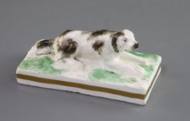 A Rockingham porcelain figure of a recumbent setter, c.1830, incised 'No. 94' and inscribed in