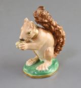 A Rockingham porcelain figure of a seated squirrel, c.1830, eating a nut, seated on an oval base,