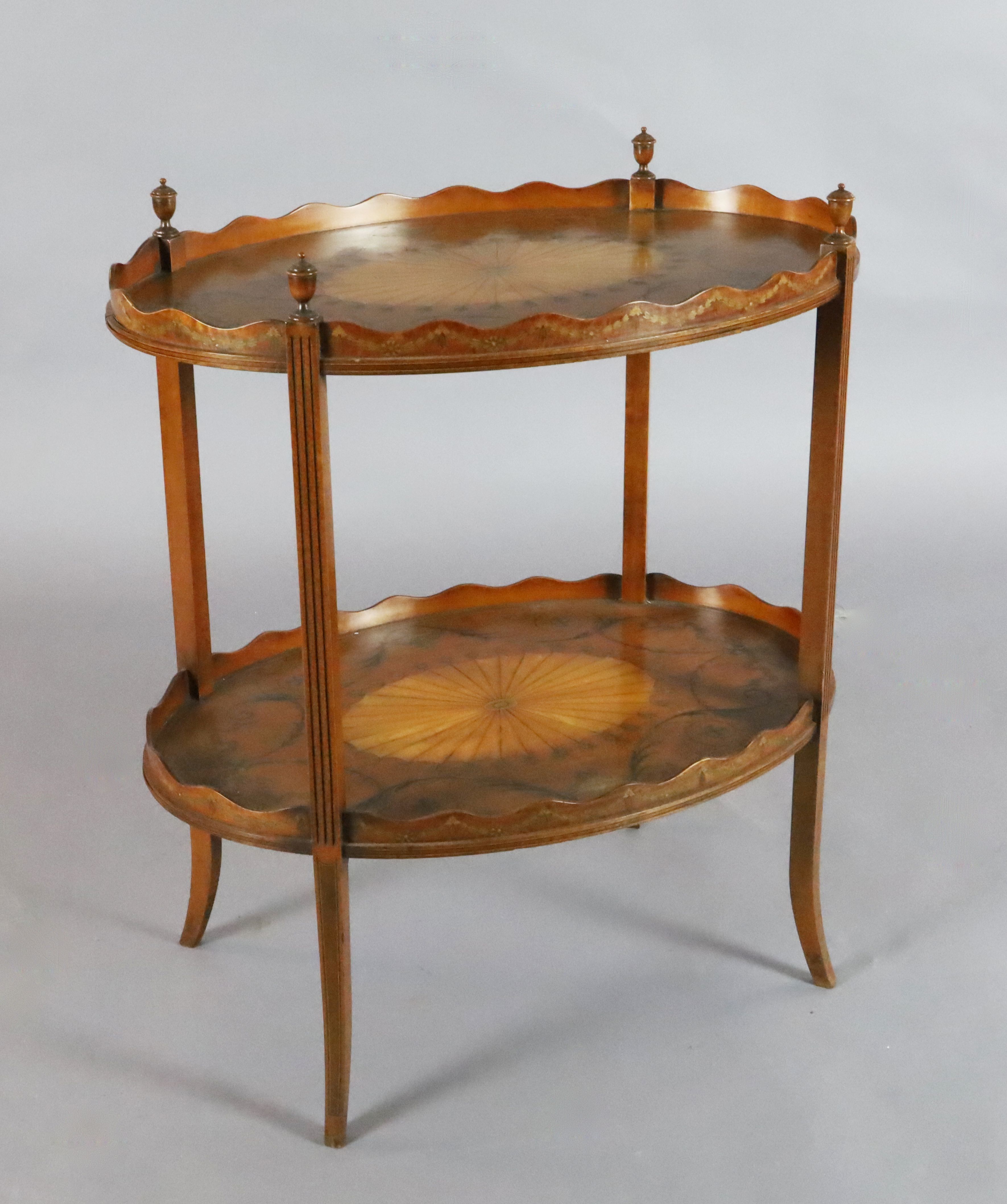 An Edwardian marquetry inlaid satinwood two tier oval occasional table, with urn and scroll