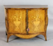 A late 19th century French marquetry inlaid serpentine commode, with two doors, decorated with