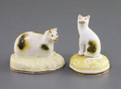 Two Samuel Alcock porcelain figures of cats, c.1840-50, the first recumbent ona yellow scrollwork