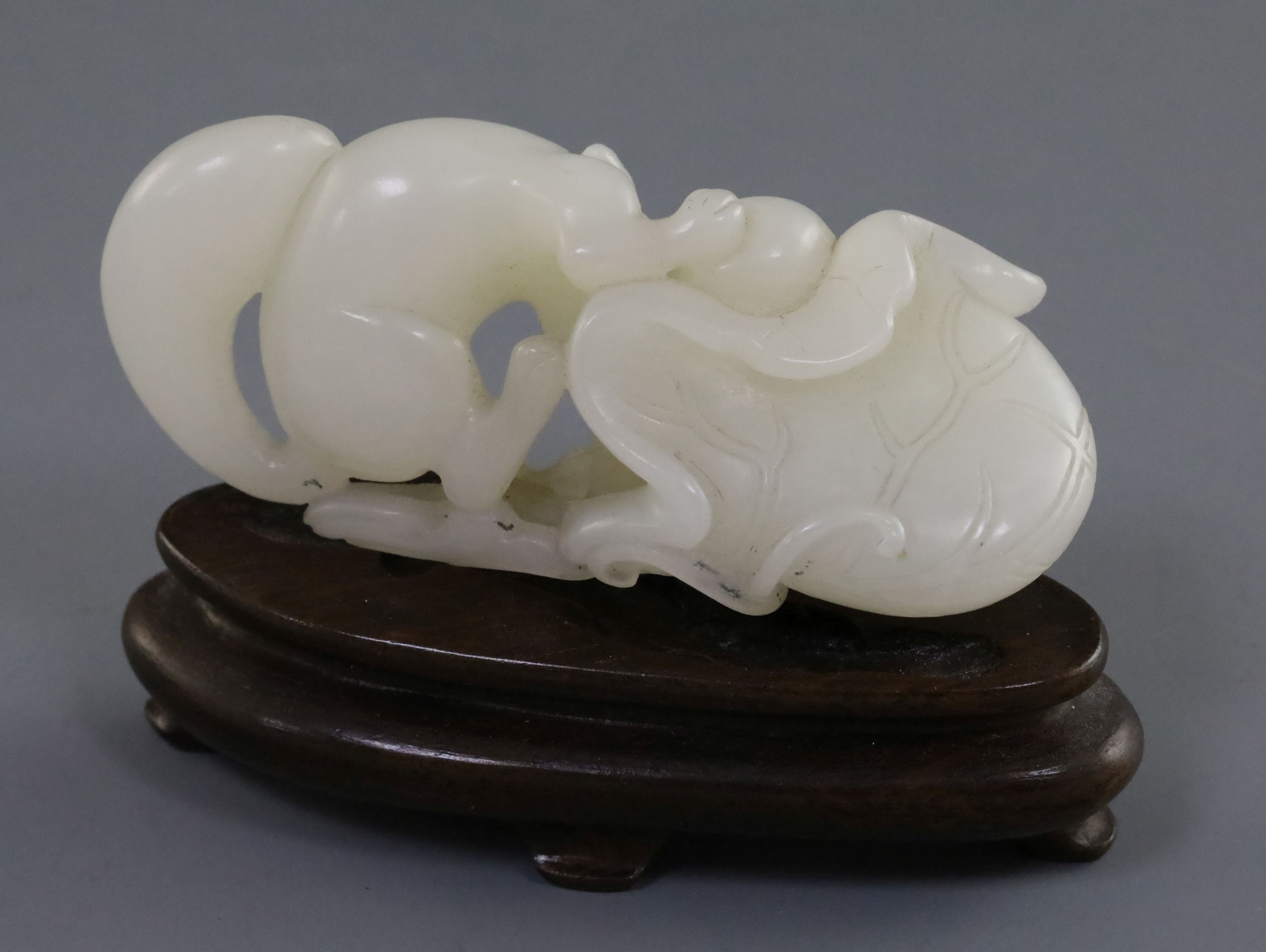 A Chinese white jade carving of a squirrel, grapes and lotus leaf, 18th/19th century, L. 6.4cm, wood - Image 2 of 2