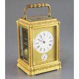 A late 19th century French ormolu quarter repeating carriage alarum clock, with floral scroll