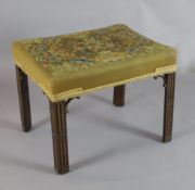 A George III mahogany stool, with later needlework seat and blind fret carved chamfered legs, W.