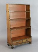 A Victorian mahogany waterfall bookcase, with three fixed shelves and two base drawers, on turned