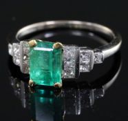 An 18ct white gold and single stone emerald ring with stepped princess cut diamond set shoulders,