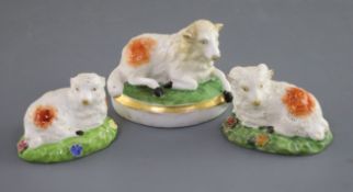 Three Rockingham porcelain figures of a recumbent sheep, c.1830, the largest on an oval base,