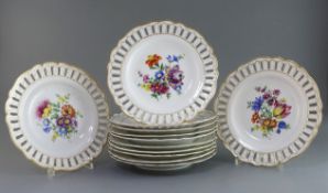 A set of twelve Meissen plates, late 19th century, each painted with a floral bouquet, within gilt