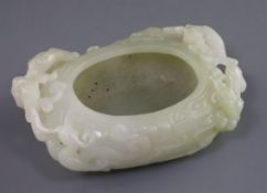 A Chinese pale celadon jade brush washer, carved in high relief and openwork with three chilong, one