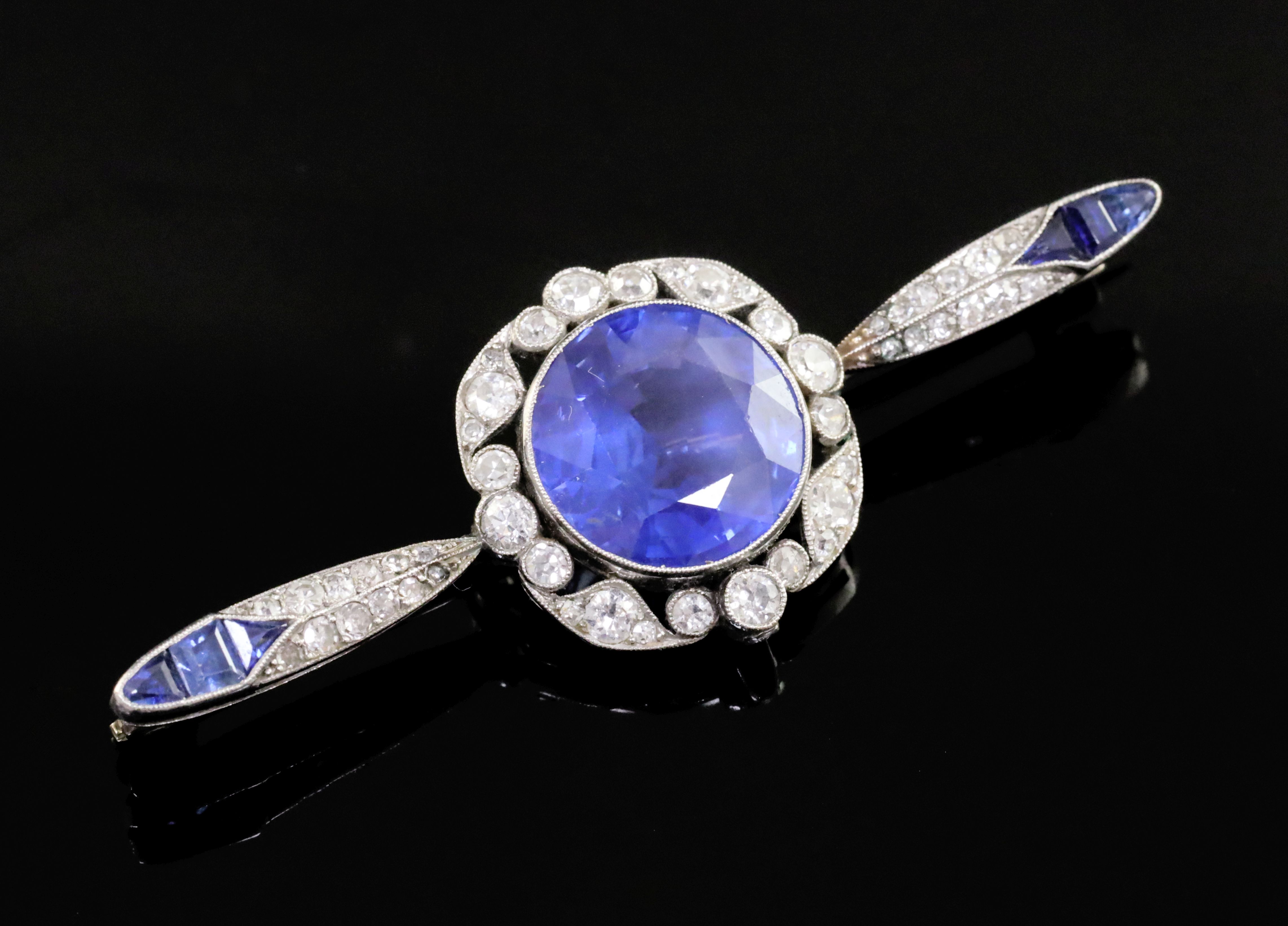 An early 20th century French platinum, sapphire and diamond bar brooch, the central round-cut