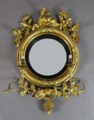 A Regency giltwood and gesso convex wall mirror, with deer and oak leaf crest, sickle and wheatsheaf