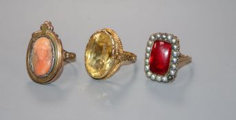 Three assorted yellow metal gem set rings including a carved coral cameo.