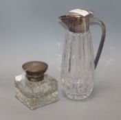 A silver-topped glass inkwell and a plated claret jug