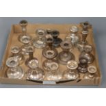 Twenty assorted early 20th century and later silver dwarf candlesticks, of varying sizes.