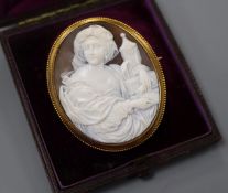 A cased yellow metal and carved oval cameo brooch, decorated with the figure of a lady with an