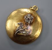 A Victorian yellow metal and diamond set locket with flower applique, 28mm.