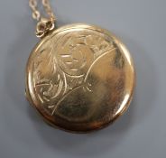 A yellow metal locket with engraved front, on a 9ct fine link chain, gross 3 grams, locket 21mm.