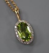 A modern 9ct gold, peridot and diamond set oval pendant, on a 9ct gold chain, pendant overall 21mm.